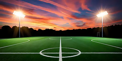 pngtree a brightly lit soccer field at dusk surrounded by trees under image 17487441